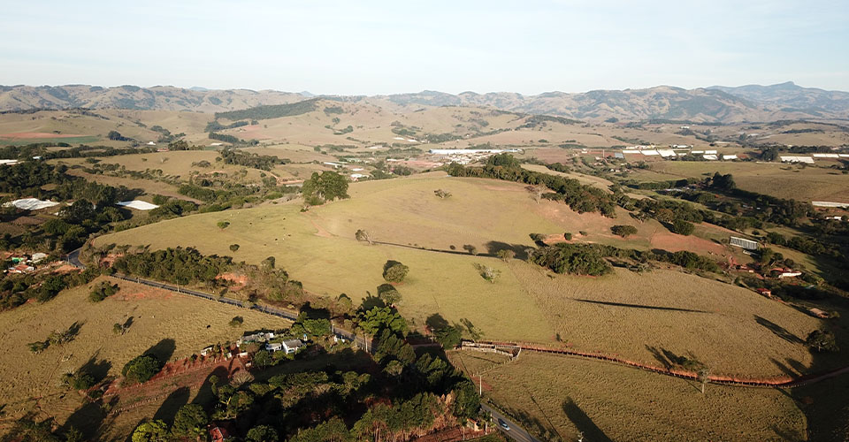 Vista aérea do terreno Edan Park em Estiva/MG, loteamento industrial e logístico com obras em andamento.